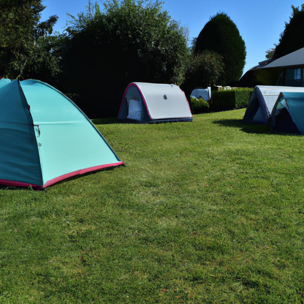 A-frames tents lined up on a grassy field with a bonfire pit in the center, surrounded by tall pine trees. A family setting up camp, unloading their car with camping gear while a dog runs around excitedly.